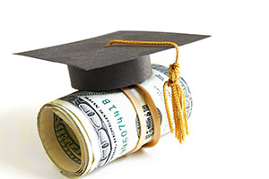 photo of graduation cap on a pile of money