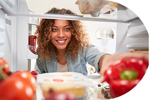 photo of woman lookin gin a refridgerator