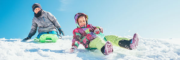 photo of kids sledding down a hill