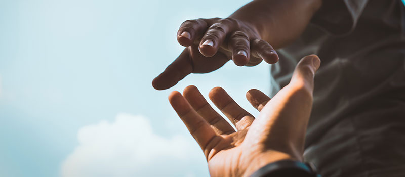 image of a hand reaching out to another hand