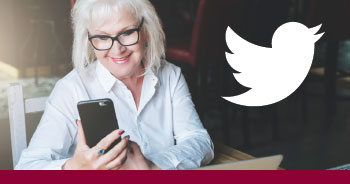 old white woman looking at phone smiling with twitter logo