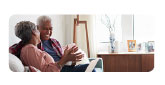 older black couple smiling on couch