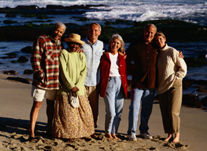 group of adults standing and smiling on beach