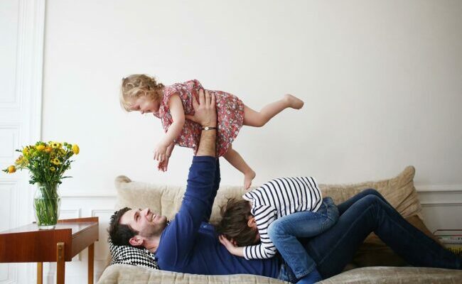 Dad playing with children on couch