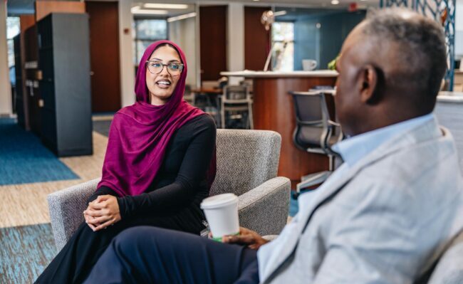 Two people sitting in chairs talking