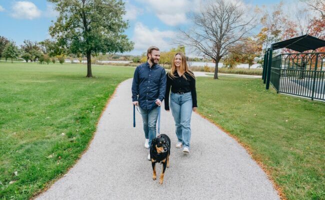 Couple walking with their dog in a park