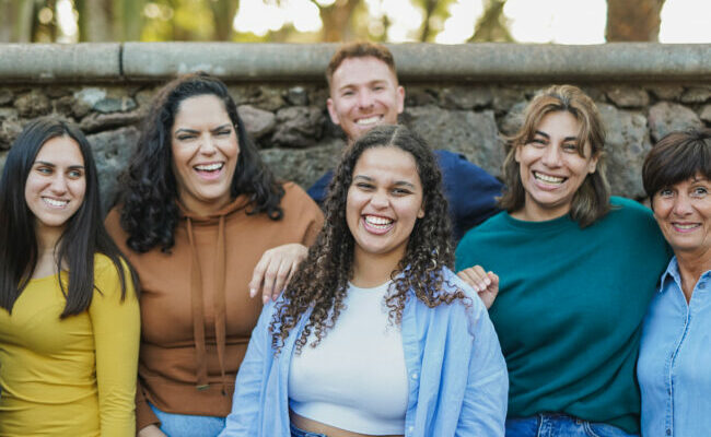 Group of multi generational people having fun together outdoor while smiling in front of camera - Community and inclusion concept