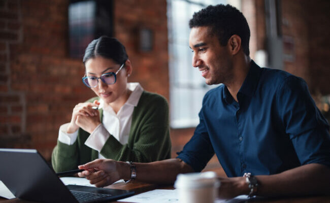 Two Professionals Collaborating on a Project in a Modern Office Environment