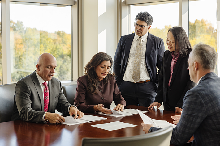 Five investment team professionals collaborating around a table.