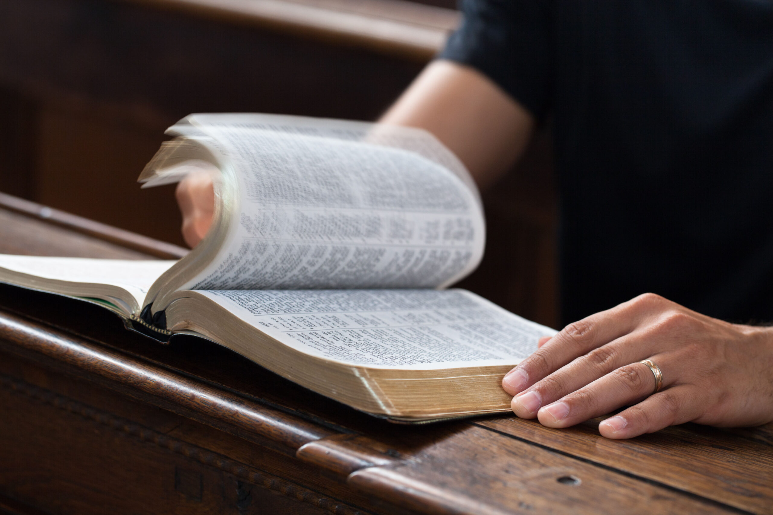 Person turning bible with focus on bible pages turning