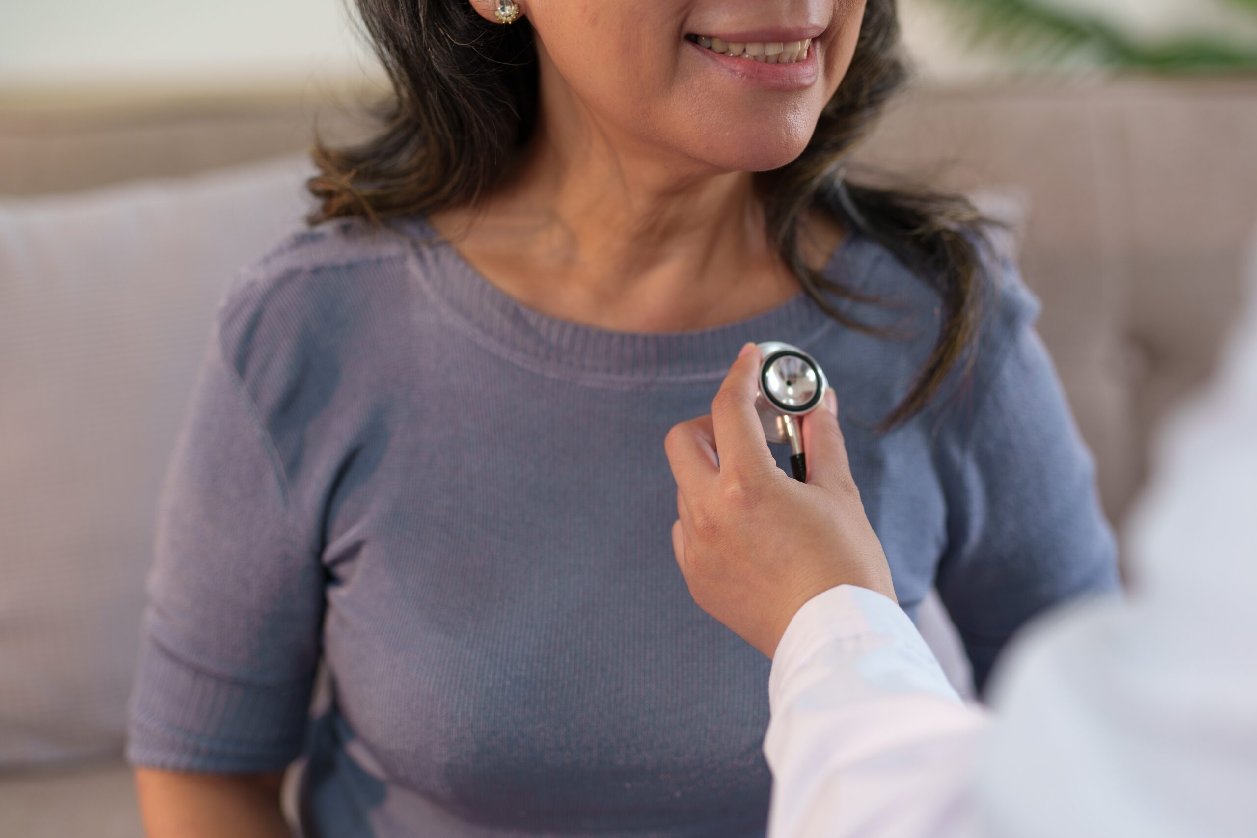 Doctor using stethoscope on woman