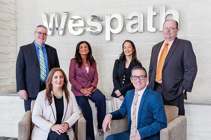 Wespath's leadership team in front of Wespath sign.